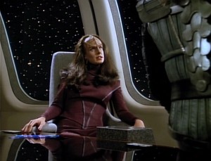 Ambassador K'Ehleyr siting in the Enterprise's observation lounge.